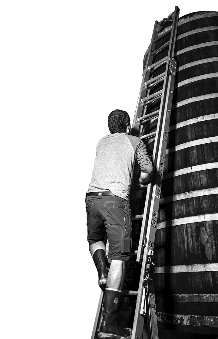 A brewer climbing a ladder to a foeder