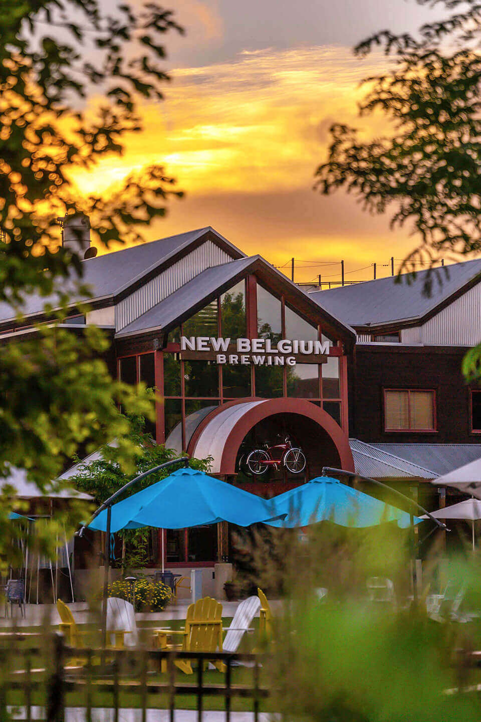 Exterior outdoor shot of New Belgium Brewing through trees. Located in Fort Collins, CO.