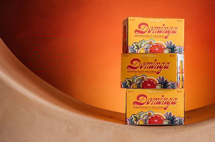 3 6-packs of Dominga stacked on top of each other against an orange background. 
