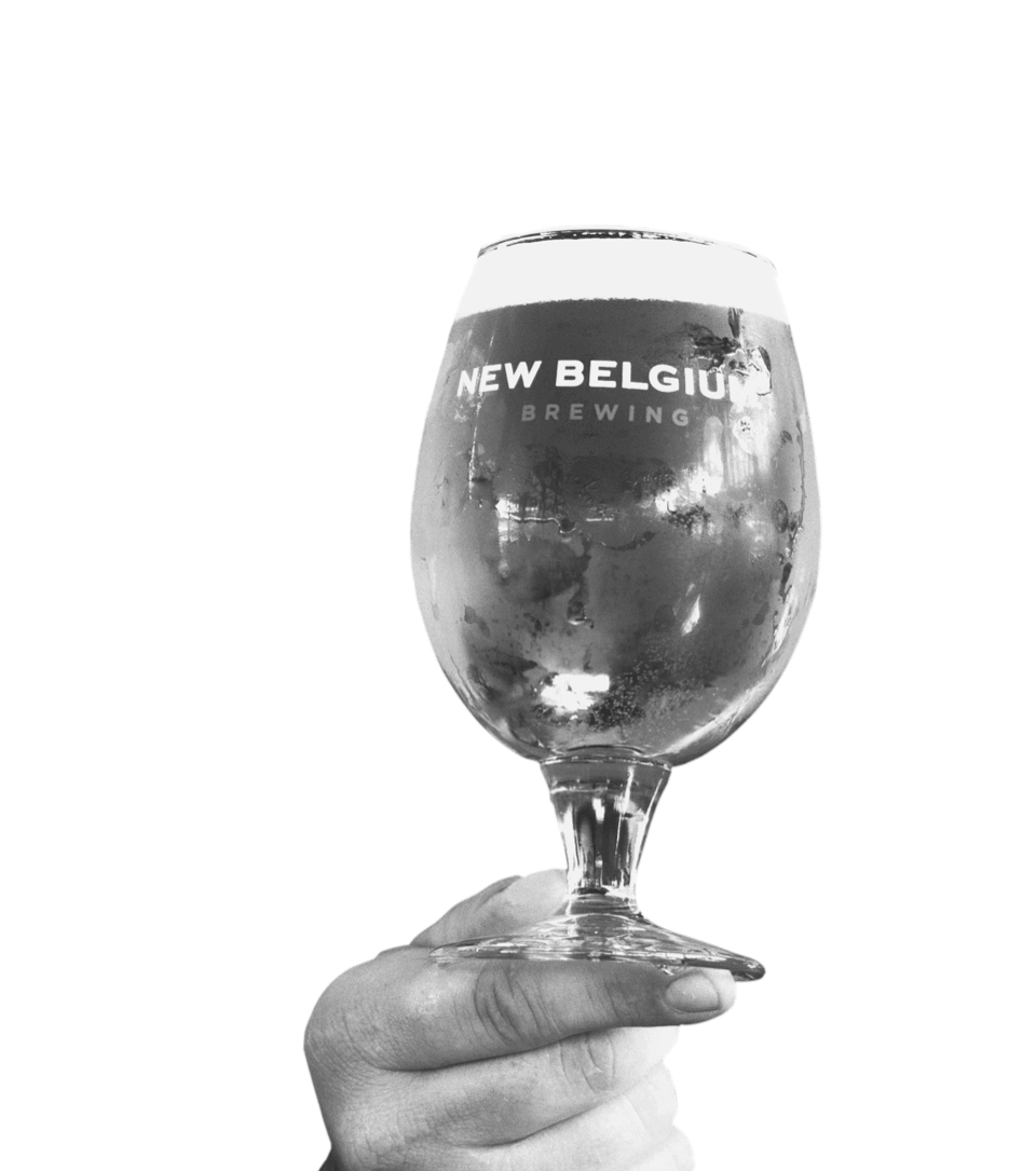 Hand holding New Belgium globe glass full of beer.
