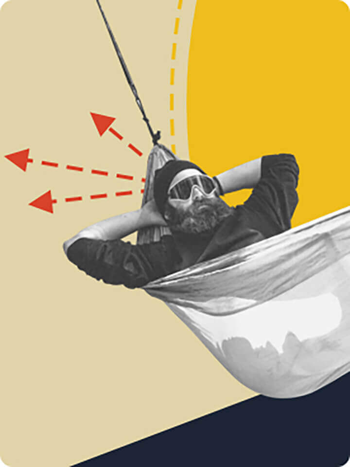 A man laying in a hammock wearing sunglasses with his hands behind his head. 