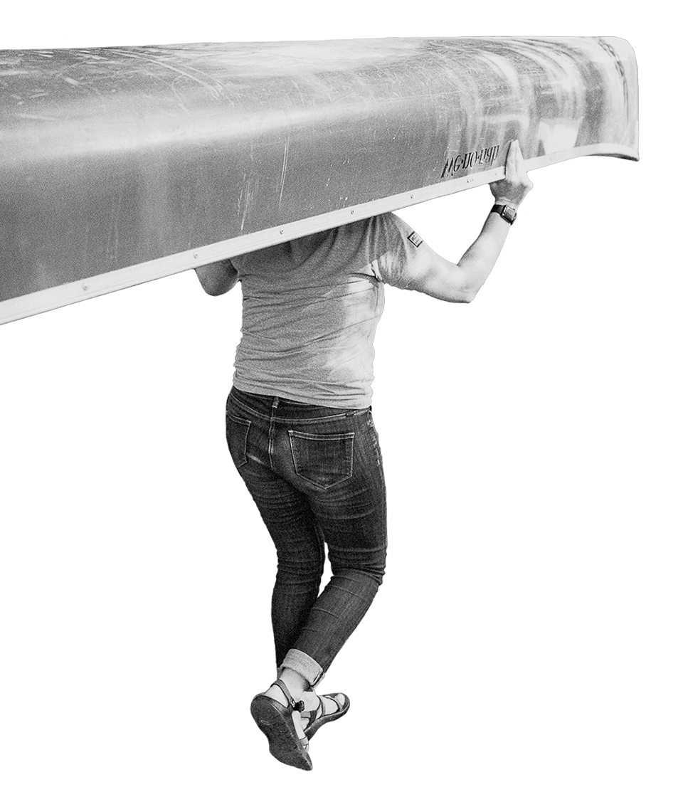 Person carrying a canoe over their head. 